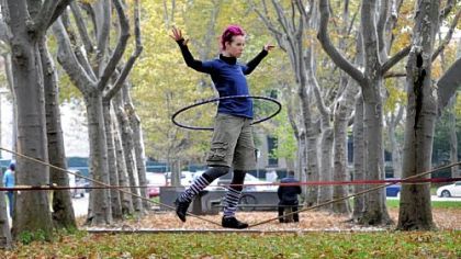Slackline Pittsburgh founder Laura Lantz walks the loose rope while spinning a hula hoop outside the Carnegie Library in Oakland. Slacklining is a balance activity similar to tightrope walking, but on a line that is loosely strung rather than tight.