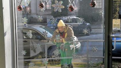 Stephen Dugger of Homestead stands outside the holiday-bedecked window Sunday at the Rainbow Kitchen in Homestead. The Jewish community joined together for its annual Mitzvah Day volunteer project.