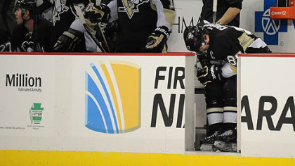 Penguins' Sidney Crosby makes his way back to the bench in pain after colliding with  teammate Chris Kunitz in the third period.