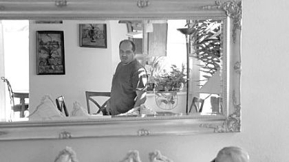 Moises Leyva earns about $35,000 a year as a school custodian, but he isn't sure if he will be able to keep this house in Las Vegas. Even though his lender, Wells Fargo, was sanctioned for improper documentation on his loan, it may still seek to foreclose on him. Here, he gets ready for work as his girlfriend, Marie Gomez, sits on the couch.