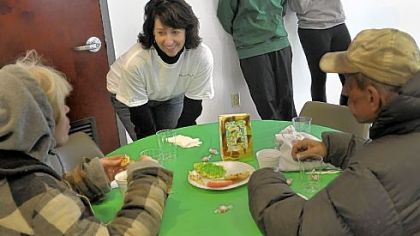 Elissa Mendelson of Upper St. Clair asks diners at the Rainbow Kitchen in Homestead if they would like baked stuffed chicken or ham for their Christmas dinner.