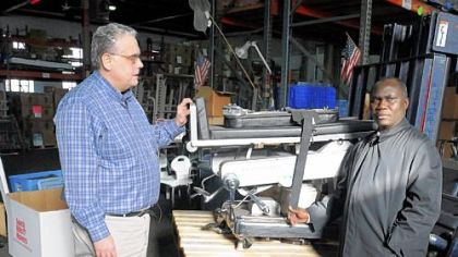 Luke Hingson, left, president of Brother's Brother Foundation, shows a operation bed to Tillman Collins, president of Grand Gedeh Association in the Americas, on Wednesday in the North Side.