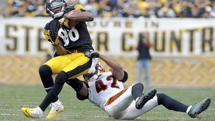 Emmanuel Sanders pulls in a pass as he's taken down by the Bengals' Chris Crocker.