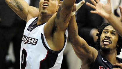 Dukes' Andre Marhold drives to hoop against  RMUs' Darren Washington.