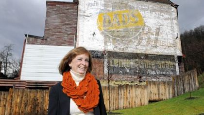 Marge McMackin in front of a Dad's Root Beer sign her father, Maurice "Red" O'Donnell, painted on a building at 1816 N. Charles St., North Side.