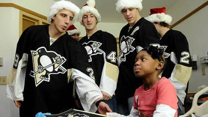 Penguins goalie Marc-Andre Fleury says goodbye to Kayleigh Williams, 7, of Arizona after he and other players stopped by Children's Hopsital of Pittsburgh of UPMC in Lawrenceville to deliver presents. Along with Fleury is Brooks Orpik, Evgeni Malkin and Matt Niskanen.