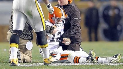Browns quarterback Colt McCoy gets attention after receiving a hit from the Steelers' James Harrison.