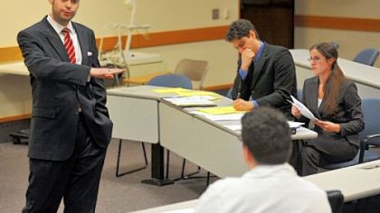 Ken Hager questions a seated John Legarreta during a mock trial in his advanced trial advocacy class at the University of Pittsburgh's School of Law.
