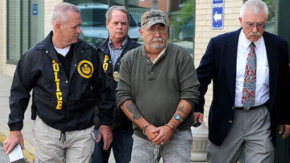 Corrections officer Harry Nicoletti, center, is escorted from the Dormont Municipal Building, where he was charged with abusing prisoners.