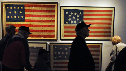 George Priatko (center), 86, of Plum and other World War II veterans visit "Stars & Stripes: An American Story" at the Heinz History Center on Tuesday. The exhibition runs through June.