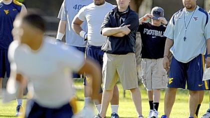West Virginia coach Dana Holgorsen, center, watches practice Friday at Barry University in Miami Shores, Fla.