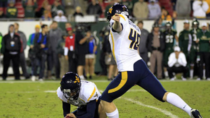 West Virginia's Michael Molinari, left, holds as kicker Tyler Bitancurt (40) winds up to attempt a game-winning field goal as time expires against South Florida last night in Tampa.