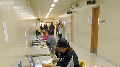 Dave Anderson, of JBLS, checks documents Thursday on the tables set up outside the County Clerk's office in the Ohio County Courthouse in Wheeling, W.Va.