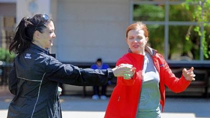 Orthopedic surgeon Dr. Vonda Wright shows aspiring marathoner Leslie Rubinkowski how to grab a cup of water while running