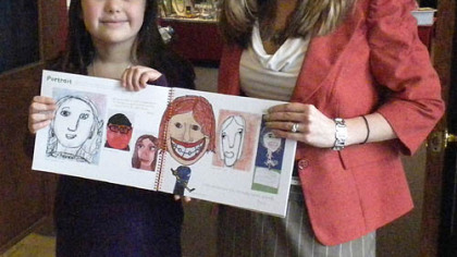 Victoria Hrach, 10, and author Katie Barnard Switzer show pages with Victoria's artwork in "Imagine American Art."