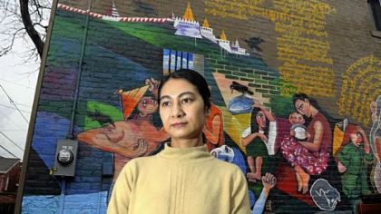 Khet Mar, a Burmese writer, by her house in the Mexican War Streets; the mural was painted by her husband and deals with Burmese life and her writing.