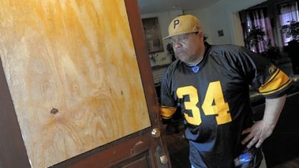 Gary Adams stands at the front door to his Bellevue home, which he says the FBI wrongly broke down as part of the Manchester drug raids Thursday. The door's cut glass was shattered in the attempt to enter the home.