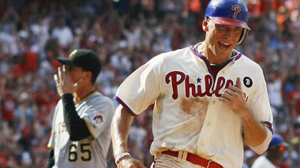 Phillies' Hunter Pence, right, scores the winning run as Pirates relief pitcher Tony Watson, left, walks off the field in the 10th inning of a baseball game.