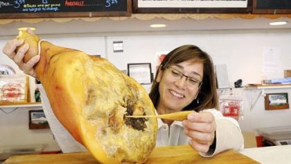 Rina Edwards, president of Parma Sausage, demonstrates how a horse-bone tool (a sonda) is used to check the curing process.