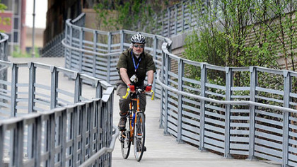 Bob Breen, 57, of Ohio Township rides his bike Thursday through the trail outside the new Convention Center Riverfront Plaza. The completion of the plaza connects the trail from Point State Park to the Strip District. Mr. Breen, who works Downtown, bikes 8 miles every day.