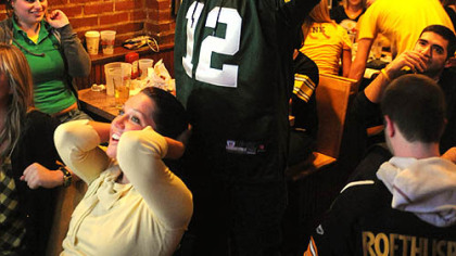 Green By fan Ed Pajewonsky of Stroughsburg, Pa., puts his hands in the air after the Steelers' final fourth down as Danielle Prima of Oakland watches in disbelief at Piper's Pub in Oakland.