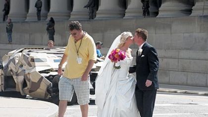 WPXI sports anchor Rich Walsh and his bride, Michele, share a kiss after getting a close look at the Batmobile (also known at The Tumbler) on the set of "The Dark Knight Rises" on Fifth Avenue in Oakland. Mr. and Mrs. Walsh had just finished their wedding ceremony at St. Paul Cathedral.