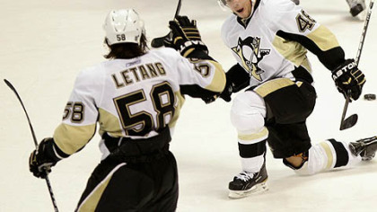 Penguins forward Tyler Kennedy  celebrates his game-winning goal in overtime with defenseman Kris Letang following Wednesday's game against the Avalanche at the Pepsi Center in Denver.