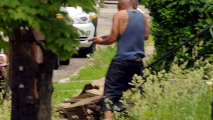 A man emerges from a house in Larimer, armed with a shotgun. He was shot by police after they ordered him to drop his weapon.