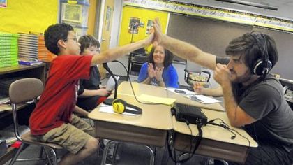 Jeff Baron, right, director of Education & Outreach of SLB Radio Productions, gives a high-five to Jaden Black, 10, a fourth-grader of Homeville Elementary in West Mifflin after recording for the "Hear Me Project."