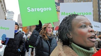 Kawthar Albe, right, a refugee from southern Sudan now living in Beechview, walks with the Pittsburgh Darfur Emergency Coalition and Partners as they march Downtown Wednesday.