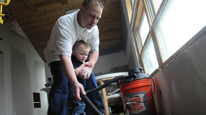 Dean Osterritter, 33, of Spring Hill vaccums dead stink bugs in his attic with his son Dean Jr., 2.