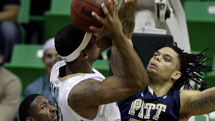 Pitt center Gary McGhee blocks a shot by South Florida center Jarrid Famous during the first half of Wednesday's game in Tampa, Fla.