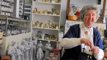 Sharon Oldaker, co-owner of the Sacred Heart of Jesus Catholic Store in Bloomfield, works on a black-and-gold rosary.