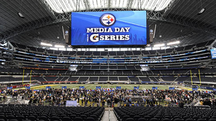 The massive video screen hangs over Steelers players as they participate in Media Day Tuesday.