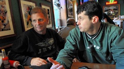 Howard Fuchs, left, of Sarasota, Fla. (formerly of the Bronx), and his son. Jason Fuchs of Petoskey, Mich., eat lunch at Primanti Brothers restaurant in Market Square, Downtown. The Jets fans are in Pittsburgh for the AFC Championship today. On the wall behind them are photos of the Steelers.