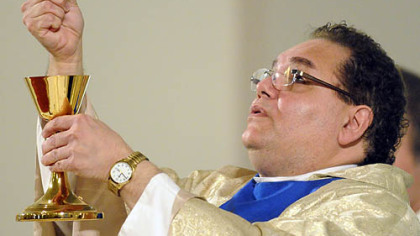 The Rev. John Dinello offers communion during a memorial Mass that was celebrated before the dedication of a memorial to the three Pittsburgh police officers.