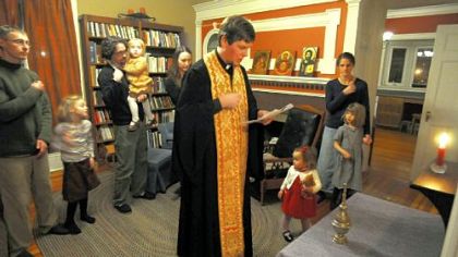 The Rev. James Purdie of St. George Antiochian Orthodox Cathedral blesses the home of his parishioners Michael and Randi Sider-Rose and their children.