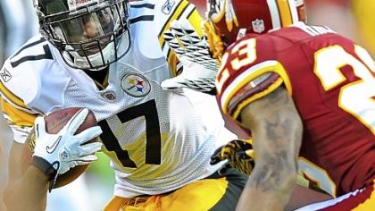 Wide receiver Mike Wallace attempts to fend off the tackle of Redskins cornerback DeAngelo Hall in the first quarter Friday night at FedEX Field.