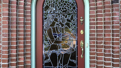 The late artist Henry Koerner designed this door for his home in 1966. It is lit by an interior spotlight, illuminating it at night.
