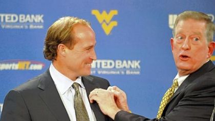 Dana Holgorsen, left, new West Virginia's football offensive coordinator and quarterbacks coach receives a West Virginia pin from head coach Bill Stewart at a press conference in Morgantown, W. Va Dec. 22, 2010.
