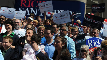 Former U.S. Sen. Rick Santorum holds his daughter Isabella as his wife Karen, not pictured, introduces him.