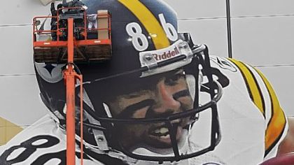 Workers put up a picture of Steelers receiver Hines Ward outside Cowboys Stadium in preparation for Super Bowl XLV Sunday in Arlington, Texas.