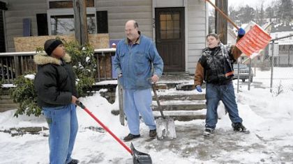 Derrick Smith, 13, left, and Benjamin Payne, 14, right, shovel snow outside the home of Jeff Owen, center, in Pitcairn. Mr. Owen is rehabbing the house and downsizing to Pitcairn from a home in Murrysville.