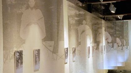 A detail of Fumino Hora's installation, "The Way of Samsara," at the Pittsburgh Glass Center. Organza banners imprinted with the image of a woman in a white kimono draw visitors into the gallery.