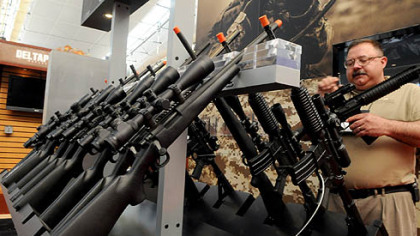 Charlie Sunderlin of Amity, Ore., sets up a display to show the range of rifle scopes by Leupold & Stevens Inc. Thursday at the David L. Lawrence Convention Center, Downtown, for the upcoming National Rifle Association convention.