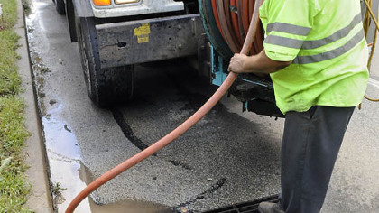 Shawn Mahoney (below) and Bob Scott of Pittsburgh Water and Sewer Authority (PWSA) contractor Jet Jack Inc. clean a catch basin along Washington Blvd.