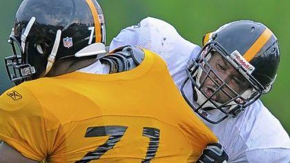 Steelers offensive tackle Tony Hills grapples for position with defensive end Corbin Bryant (71) during workouts at training camp at Saint Vincent College.