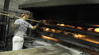 Mike Ambeliotis works the oven at the Mediterra Bakehouse in Robinson.