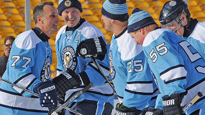 From left to right, Penguins alumni Paul Coffey, Mario Lemieux, Kevin Stevens and Larry Murphy celebrate a goal against during Friday's game at Heinz Field.