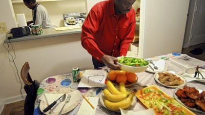 Ismail Omar, foreground, prepares for dinner with Mohamed Idris.